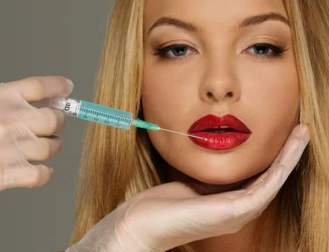 Beautiful young woman red lips with botox syringe Stock Photos