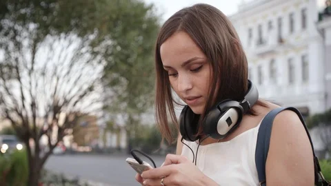 Beautiful young woman relax listening music on city street. Stock Footage