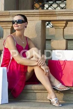 Beautiful young woman relaxing with shopping bags Stock Photos