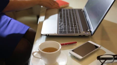 Beautiful young woman is seating indoors at a cafe restaurant, holding a coffee Stock Footage