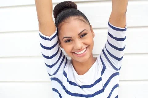 Beautiful young woman smiling with arms raised 스톡 사진