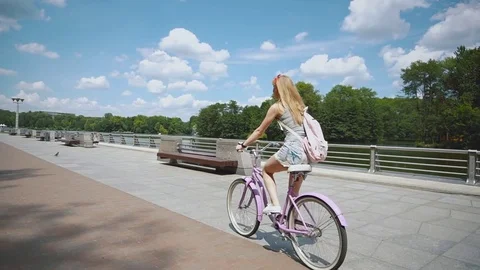 Beautiful young woman smiling while riding her bicycle on a sunny summer day Stock Footage