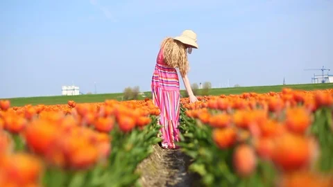 Beautiful young woman standing in colorful tulip field Stock Footage