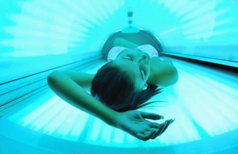 Beautiful young woman tanning in solarium Stock Photos