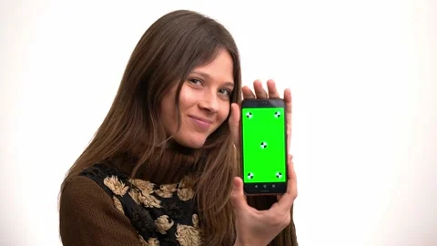 Beautiful young woman using and showing the screen of an smartphone 库存影片 202264367