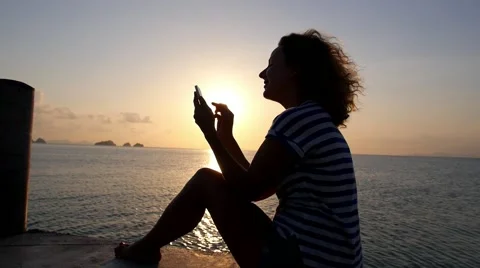 Beautiful Young Woman Using Cellphone At Sunset Stockbeeldmateriaal 49200514