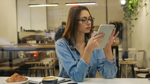 Beautiful young woman using tablet computer in cafe, view through the window Stock Footage 72361710