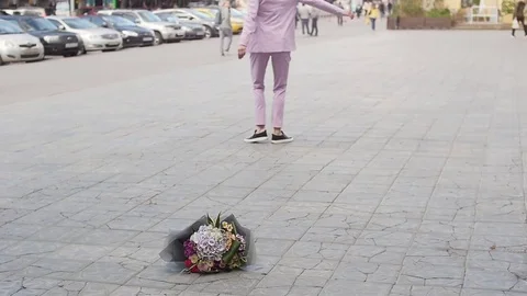 Beautiful young woman walks on a sidewalk near a city park, student girl holding Stock Footage