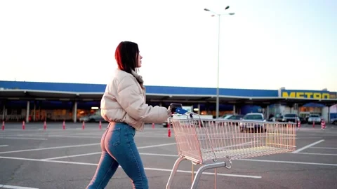 A beautiful young woman walks through the parking Stock Footage 236257553