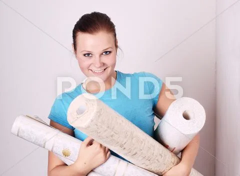 Beautiful young woman with the wallpaper in the hands of Stock Photos