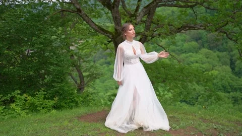 Beautiful young woman in a wedding dress in the woods in the mountains Stock Footage