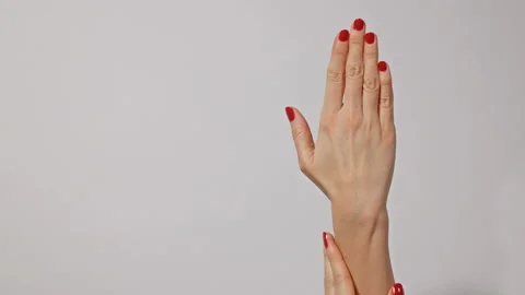 Beautiful young woman's hands with bright red manicure, one hand gently Stock Footage 106455449
