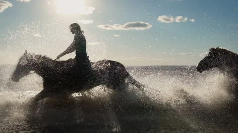 Beautiful young women horse riding at a beach Stock Footage
