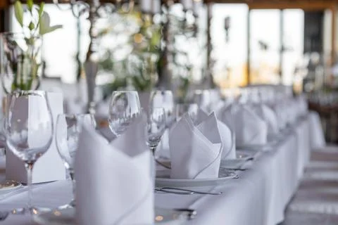 A beautifully arranged dining table features crisp white linens, neatly folde Foto stock