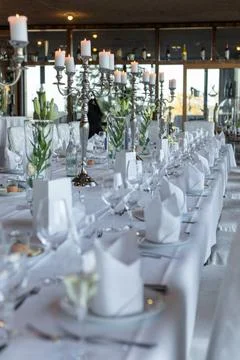 A beautifully arranged dining table features white tablecloths, sparkling gla Stock Photos