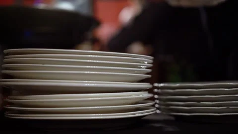 A beautifully arranged stack of white plates in a stylish restaurant setting Stock Footage 290932904
