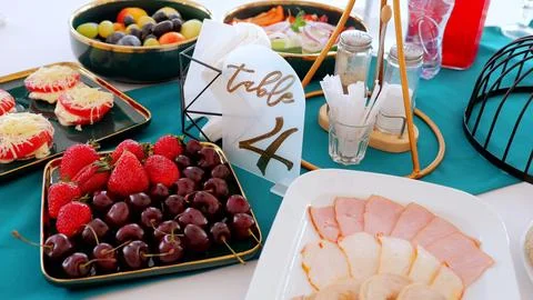 Beautifully arranged table setting featuring a table 4 sign, platters of fresh Stock Photos