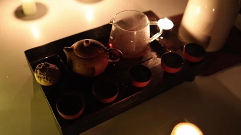 A beautifully arranged tea setup featuring a clay teapot, a glass teapot, and cl Stock Footage 299384764