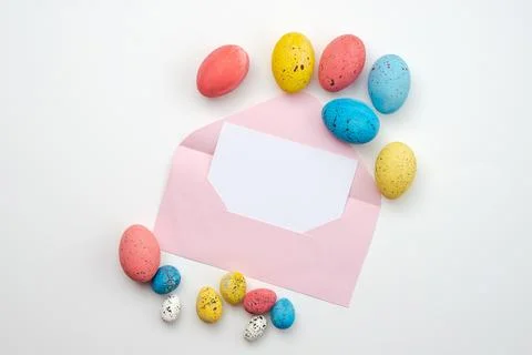 Beautifully colored Easter eggs and a beautiful blank envelope on a white b.. Stock Photos