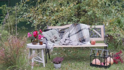 Beautifully decorated bench in the garden in the fall, at the bench swaying Stock Footage 161643726