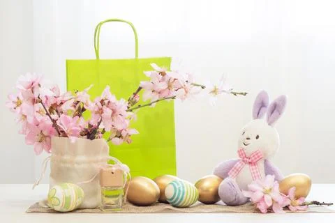Beautifully decorated Easter table with a toy bunny, golden and painted eggs Stock Photos