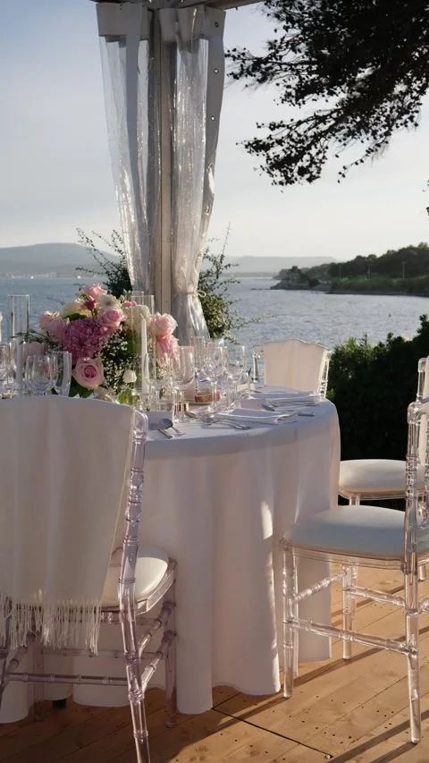 Beautifully decorated wedding table with pink flowers, crystal glasses, and 库存影片 344007365