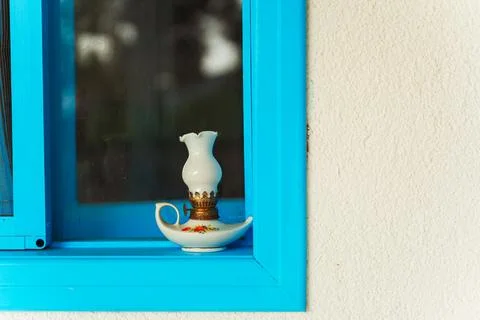 A beautifully designed blue window featuring a lamp on the window sill Stock Photos