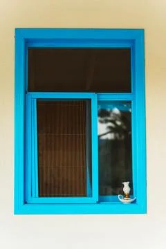 A beautifully designed blue window featuring a lamp on the window sill Stock Photos