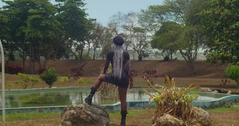 A beautifully framed medium shot of a dark-skinned young woman in a leather Stock Footage 336650007