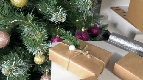 Beautifully packed gift boxes on the background of a Christmas tree, preparing Stock Footage 255657160