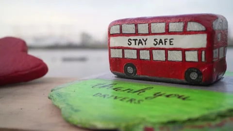 Beautifully painted rock in shape of a bus with stay safe writing on it Stock Footage 130228535