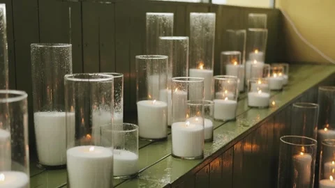 A beautifully serene and tranquil array of lit candles, elegantly set in glass Stock Footage 318064082