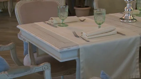 Beautifully served table with white tablecloth and chairs Stock Footage 72302296