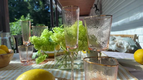 Beautifully set summer table on a veranda with lemons, hydrangeas, and elegant g Stock Footage 312408610
