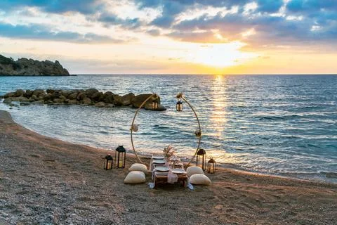 A beautifully set up table on the beach at sunset, Stock Photos