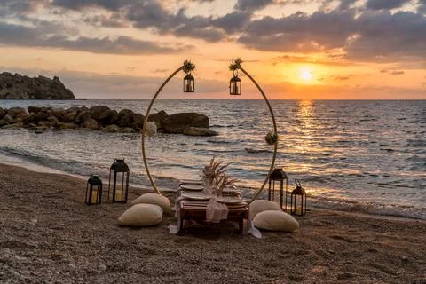 A beautifully set up table on the beach at sunset, Stock Photos
