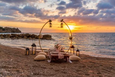 A beautifully set up table on the beach at sunset, Stock Photos