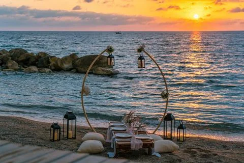 A beautifully set up table on the beach at sunset, Stock Photos