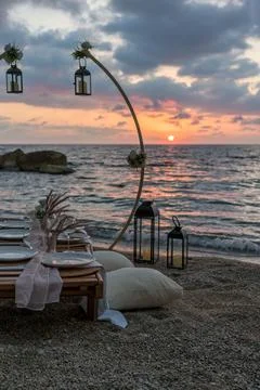 A beautifully set up table on the beach at sunset, Stock Photos