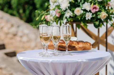 A beautifully set wedding table features three champagne glasses, rustic brea Stock Photos