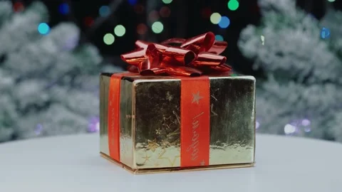 A beautifully wrapped gift with a bow on a background of lights.Close-up Video stock 149176406