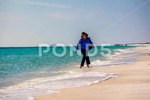 Beautiiful woman walking on a sunny white sand beach 1032-69 Stock Photos