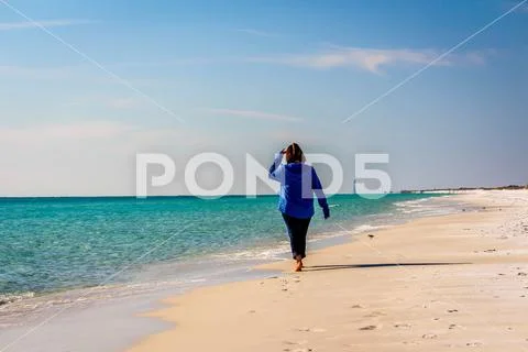 Beautiiful woman walking on a sunny white sand beach 0987-24 Stock Photos