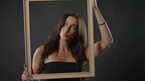 Beauty and self-perception concept, young woman posing with empty picture frame Stock Footage 336936722