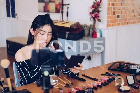 Beauty blogger live broadcasting cosmetic makeup tutorial on social media. Stock Photos