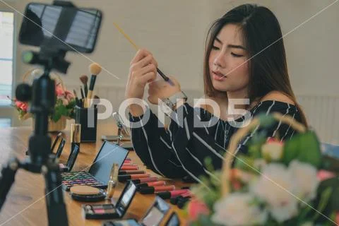 Beauty blogger live broadcasting cosmetic makeup tutorial on social media. Stock Photos