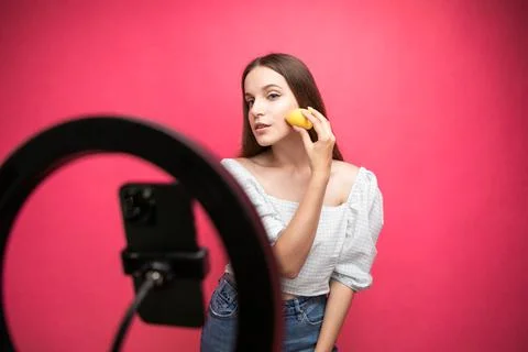 Beauty blogger recording makeup tutorial on pink background Stock Photos