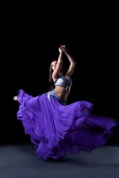 Beauty dancer posing in dark with fly purple veil Stock Photos