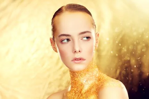 Beauty, fashion gold concept. Portrait of a beautiful girl model with golden  Stock Photos