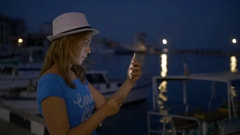 Beauty happy young girl taking picture of beautiful night city on smart phone Stock Footage